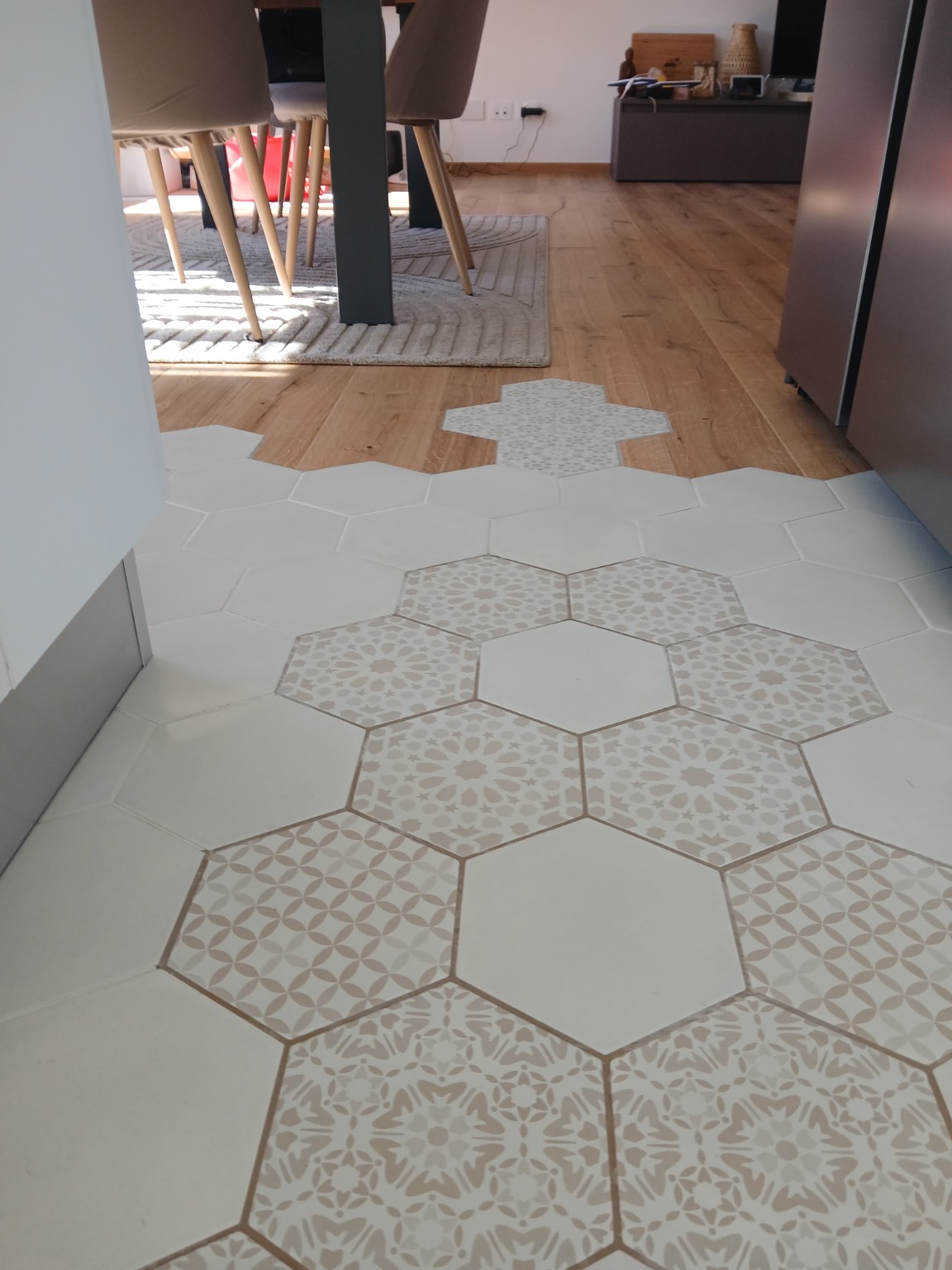 Raccordo tra pavimento in legno e piastrelle esagonali decorative