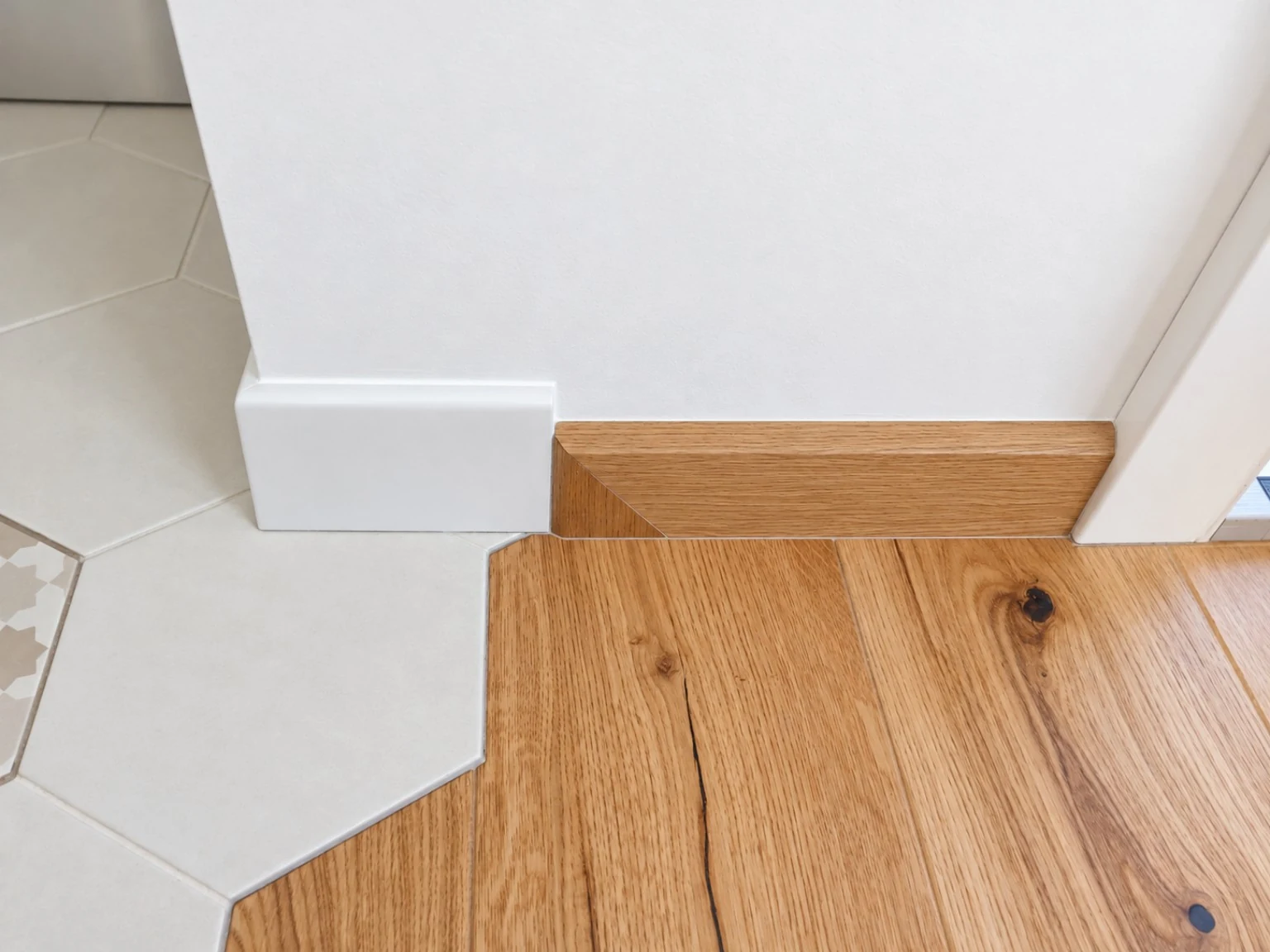 Anche il battiscopa segue il disegno. Raccordo tra battiscopa in legno e ceramica.
